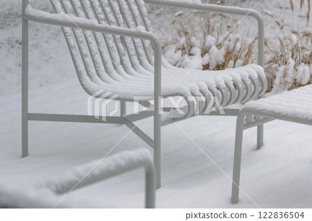 Patio Lounge Chair and Table covered in snow. 122836504
