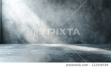Large, empty room with a wall that is grey and has a lot of texture. The room is illuminated by sunlight coming in through a window 122836584