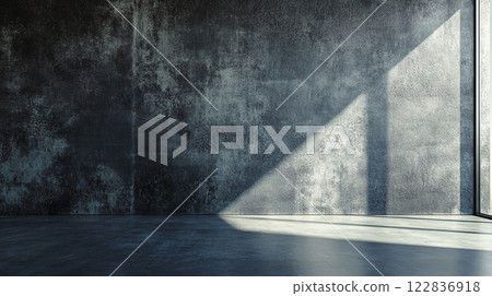 Large, empty room with a wall that is covered in a textured, grey paint. The room is illuminated by a window, casting a shadow on the wall. Scene is somewhat somber and quiet Large, empty room with a wall that is covered in a textured, grey paint. The room is illuminated by a window, casting a shadow on the wall. Scene is somewhat somber and quiet 122836918