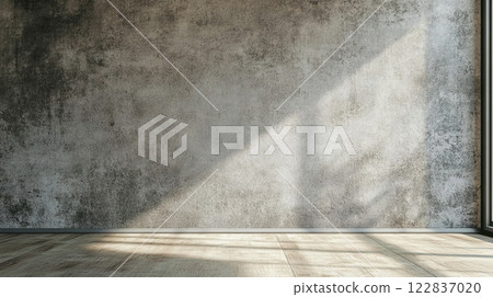 Large, empty room with a wall that is covered in a textured, gray paint. The room is filled with natural light coming in through a window, creating a warm and inviting atmosphere Large, empty room with a wall that is covered in a textured, gray paint. The room is filled with natural light coming in through a window, creating a warm and inviting atmosphere 122837020