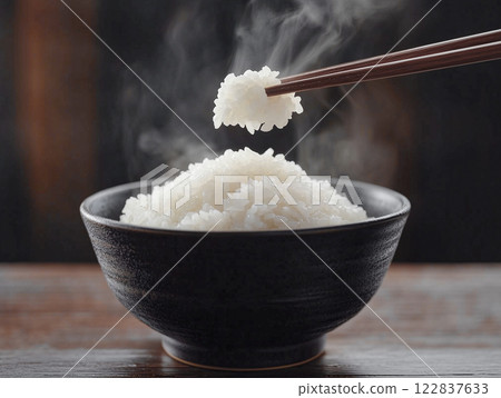 用筷子將碗裡的白飯夾起來。食物圖像素材 122837633