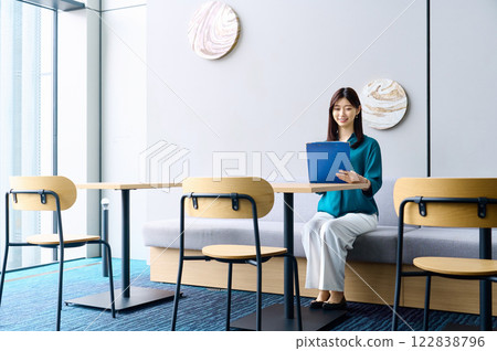 A businesswoman in casual clothes checking documents at a cafe. Photo courtesy of Sky Perfect Tokyo Media Center. 122838796