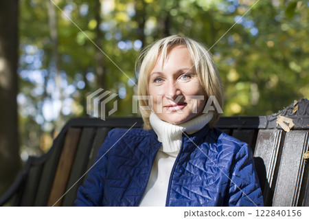 Ordinary middle-aged woman on a park bench 122840156