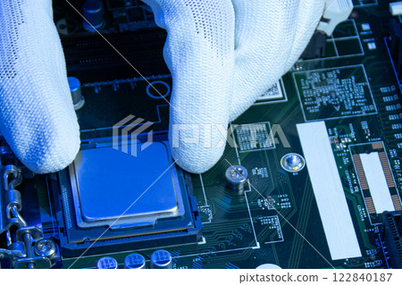 Close-up view of technician installing CPU onto motherboard. 122840187