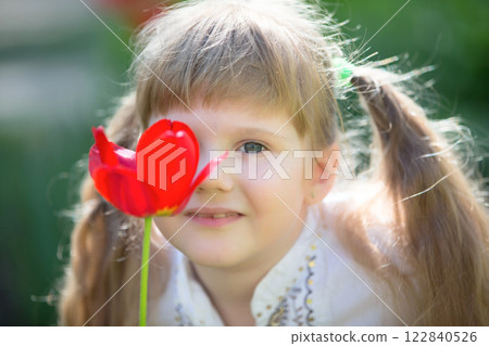 Creative portrait of a little girl with a tulip. Creative portrait of a little girl with a tulip. 122840526