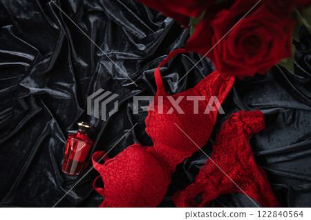 Lace women's red underwear, lingerie and red roses for Valentine's day on dark. Romantic dating. View from above. Copy space. 122840564