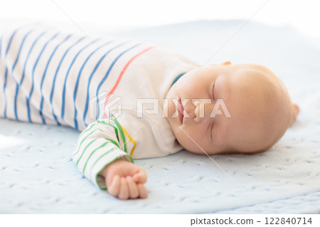 Little baby on white bed 122840714