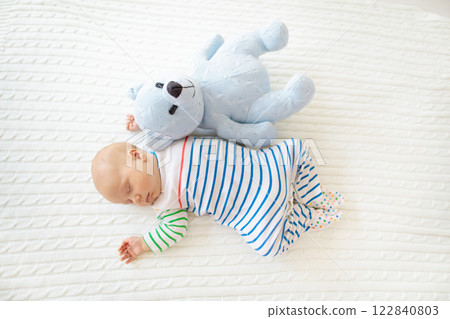Little baby on white bed 122840803