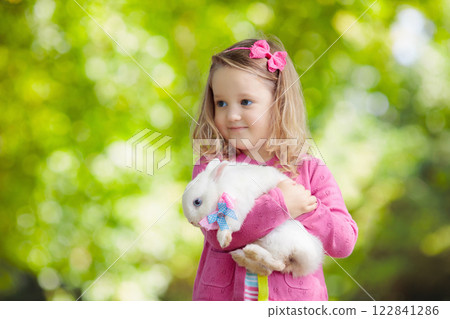 Little girl playing with rabbit 122841286