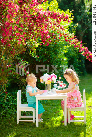 Kids having fun at garden tea party 122841442