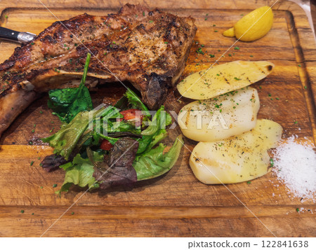 Savory grilled steak accompanied by fresh vegetables and lemon slice. 122841638