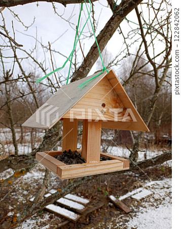 Wooden bird feeder with sunflower seeds Wooden bird feeder with sunflower seeds 122842062
