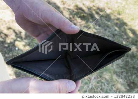 Man holding empty black leader partmone in the hands. The wallet without money for bankrupt concept. Man holding empty black leader partmone in the hands. The wallet without money for bankrupt concept. 122842258