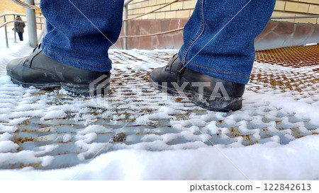 close-up of men's legs in boots and jeans standing on a metal ramp close-up of men's legs in boots and jeans standing on a metal ramp 122842613