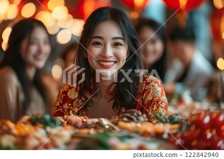 Young woman smiling during chinese new year's eve dinner 122842940