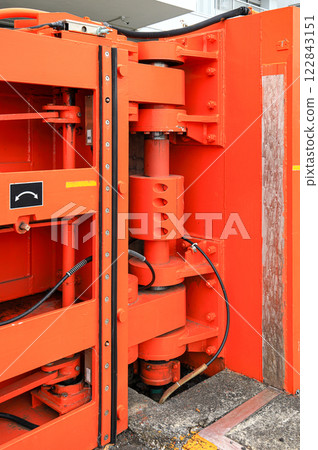 Hydraulic Hinge of big red gate at port, steel gate for Water retention and port traffic. Hydraulic Hinge of big red gate at port, steel gate for Water retention and port traffic. 122843151
