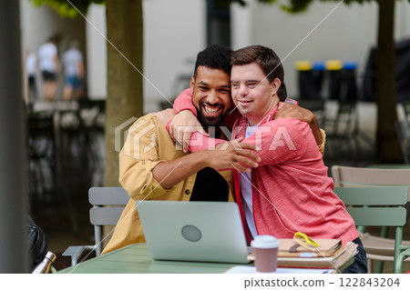 Young man with Down syndrome hugging his special educator teacher. Young man with Down syndrome hugging his special educator teacher. 122843204