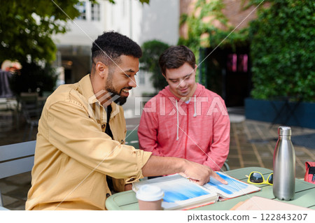 Special educator using multi sensory teaching methods with young man with Down syndrome. Special educator using multi sensory teaching methods with young man with Down syndrome. 122843207