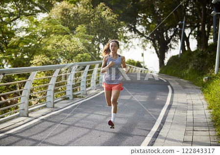 young asian woman running jogging outdoors 122843317
