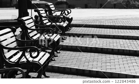 Benches lined up on the gentle steps of the square Benches lined up on the gentle steps of the square 122843486