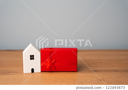 Miniature house and gift box. Housing as a gift. Win an apartment in the lottery. To inherit property. Holiday discounts. Buying an apartment at a low price. Sale of real estate. Present Miniature house and gift box. Housing as a gift. Win an apartment in the lottery. To inherit property. Holiday discounts. Buying an apartment at a low price. Sale of real estate. Present 122843673