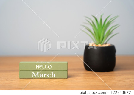 Wooden blocks Hello March and flower on the table. Concept of beginning of spring, new decade 122843677
