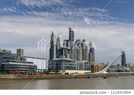 A bridge over water with a city skyline in the background 122843904