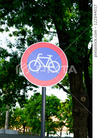 There is a vibrant red and blue sign prominently featuring a bicycle on it There is a vibrant red and blue sign prominently featuring a bicycle on it 122844017