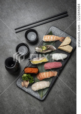 omakase mixed sushi set with sake on grey background omakase mixed sushi set with sake on grey background 122844064