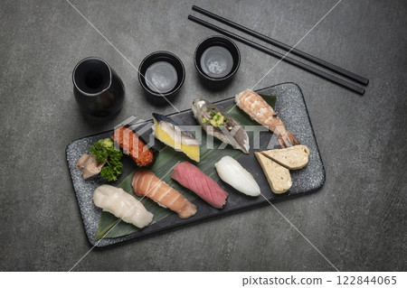 omakase mixed sushi set with sake on grey background omakase mixed sushi set with sake on grey background 122844065