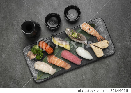 omakase mixed sushi set with sake on grey background omakase mixed sushi set with sake on grey background 122844066