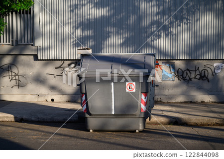 A gray garbage can is strategically placed on the side of the road A gray garbage can is strategically placed on the side of the road 122844098