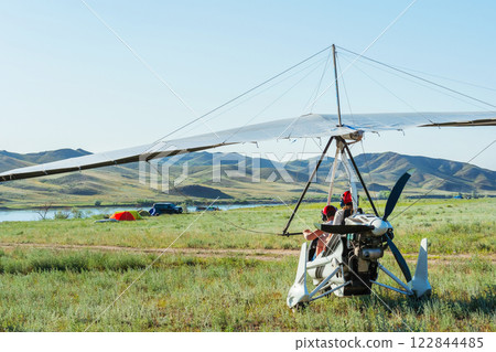hang glider takeoff in the Kazakh steppe. light aircraft with a pilot and passenger 122844485