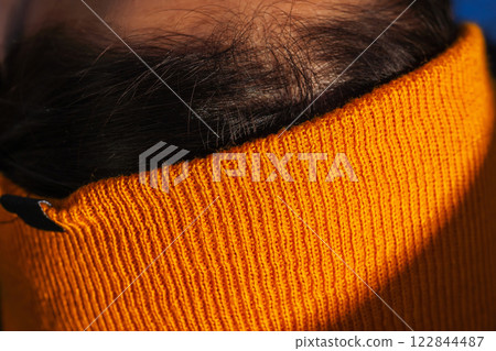winter orange hat on girl's head. synthetic headdress on head 122844487