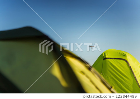 Hang glider for riding tourists in the field. Two-seater hang glider flying in the sky Hang glider for riding tourists in the field. Two-seater hang glider flying in the sky 122844489