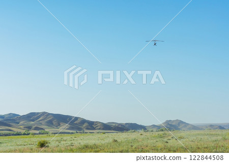 hang glider takeoff in the Kazakh steppe. light aircraft with a pilot and passenger 122844508