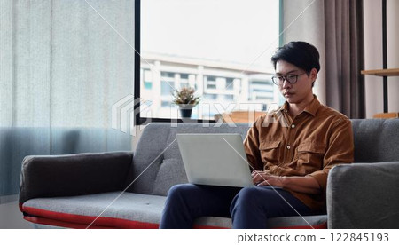 A man who uses a personal computer in the living room A man who uses a personal computer in the living room 122845193