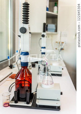 Laboratory equipment, titration of permanganate index Manual titration station with brown bottle. 122845304