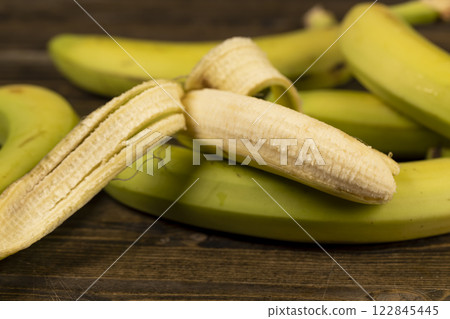 a ripe banana with a yellow-green peel is on the table a ripe banana with a yellow-green peel is on the table 122845445