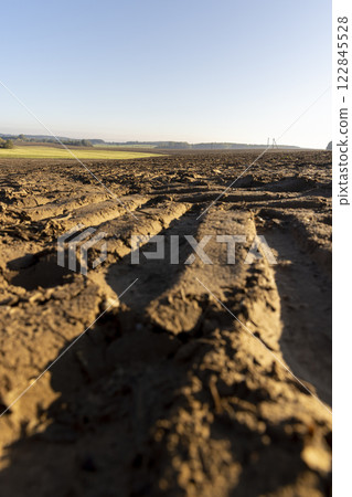 traces of tractors and other agricultural machinery on the soil in the field 122845528