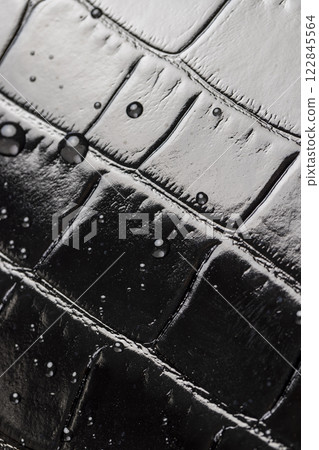 polished leather dyed black with embossed crocodile leather covered with water droplets polished leather dyed black with embossed crocodile leather covered with water droplets 122845564
