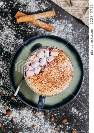 Cup of hot chocolate with marshmallows and cocoa powder on a rustic dark background Cup of hot chocolate with marshmallows and cocoa powder on a rustic dark background 122845738