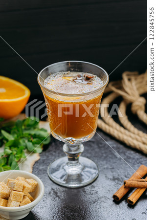 Aromatic spiced tea with citrus, cinnamon, and fresh herbs in a glass goblet, cozy moments Aromatic spiced tea with citrus, cinnamon, and fresh herbs in a glass goblet, cozy moments 122845756