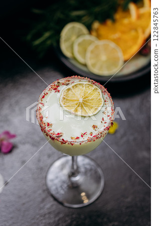 Elegant citrus cocktail in tall glass with floral garnish and dried lime slice, perfect for summer Elegant citrus cocktail in tall glass with floral garnish and dried lime slice, perfect for summer 122845763