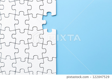 Plain jigsaw puzzle on a blue background Plain jigsaw puzzle on a blue background 122847529