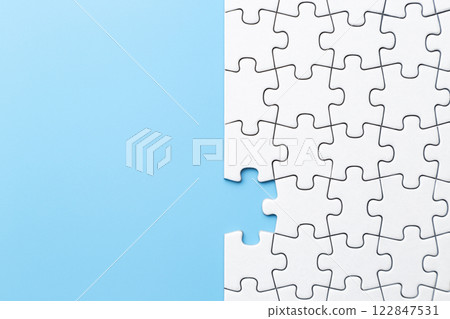 Plain jigsaw puzzle on a blue background Plain jigsaw puzzle on a blue background 122847531