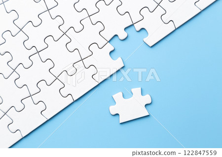 Plain jigsaw puzzle on a blue background Plain jigsaw puzzle on a blue background 122847559