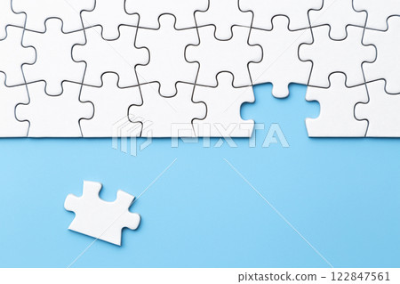 Plain jigsaw puzzle on a blue background 122847561