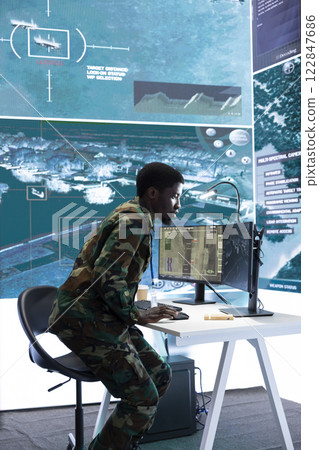 Team of military specialists in command post monitoring satellite data, integrates real time information from cctv footage. Working on decision making for strategic defense missions and security. 122847686