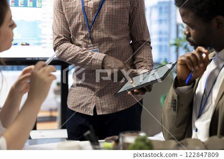 Financial manager presenting his market expansion ideas in a meeting with the advisory board, working to increase business profit. Team members evaluating market trends to create a strategy. 122847809